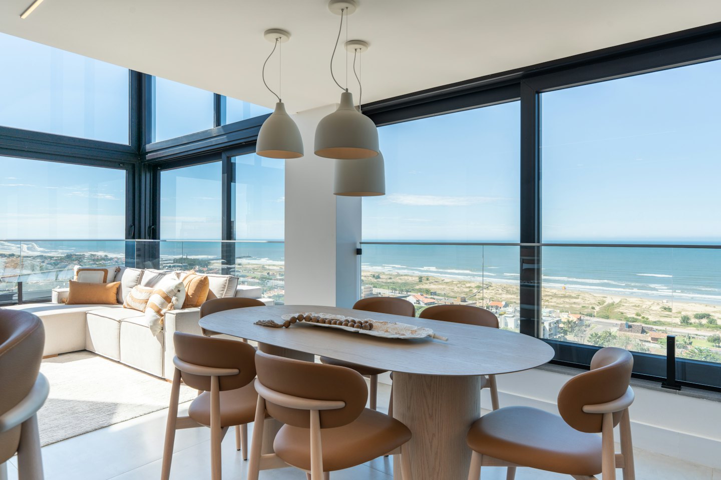 Modern dining and living area overlooking the ocean coastline.